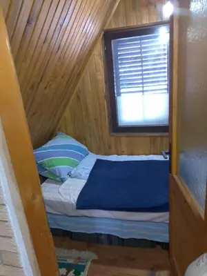 a small bed in a wooden room with a window at KopanikSkiRooms15e in Kopaonik