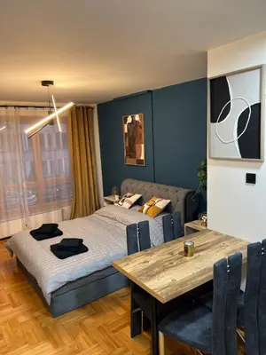 a bedroom with a bed and a wooden table at LP Premium Studio in Niš