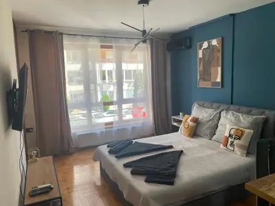 a bedroom with a bed with blue walls and a window at LP Premium Studio in Niš