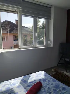 a bedroom with a bed and a large window at Apartman Slavica in Vrnjačka Banja