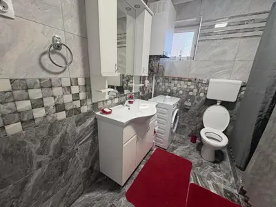 a bathroom with a white toilet and a sink at Apartman Slavica in Vrnjačka Banja