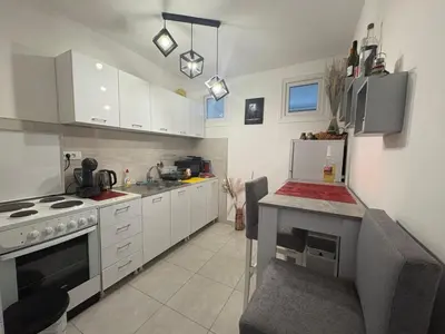 a kitchen with white cabinets and a stove top oven at Apartman Slavica in Vrnjačka Banja