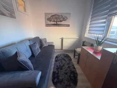 a living room with a blue couch and a table at Apartman Slavica in Vrnjačka Banja