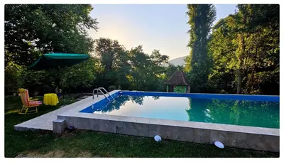 a swimming pool in a yard with an umbrella at Zvezdano nebo in Svrljig
