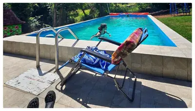 a chair with a surfboard on it next to a swimming pool at Zvezdano nebo in Svrljig