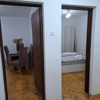 a mirror in a room with a table and a bed at Apartman Magic in Soko Banja
