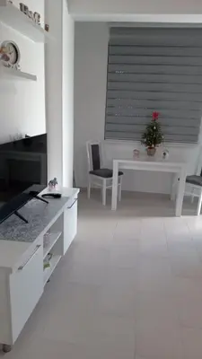 a white kitchen with a table with a christmas tree on it at Crnjanski Paun L in Jagodina