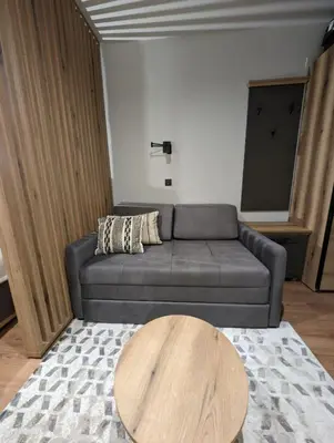 a living room with a couch and a wooden table at BratSki Apartman - 200m od gondole in Brzeće