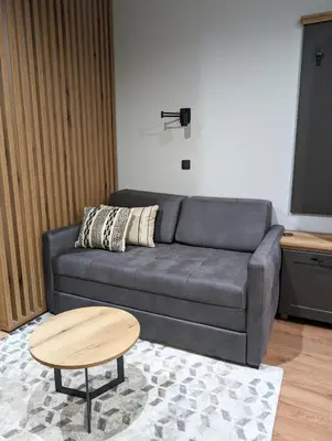 a living room with a couch and a table at BratSki Apartman - 200m od gondole in Brzeće