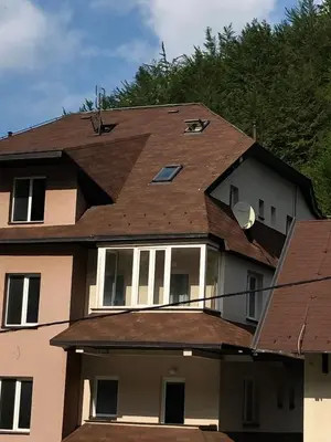 a house with a shingled roof at LOVE apartman JeLEna in Brzeće