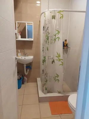 a bathroom with a shower curtain with plants on it at Apartmani Popović in Knjazevac.