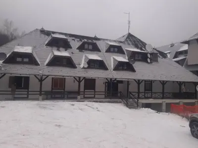 a large house with snow on the roof at Apartman Ema,Bela Reka,Brzece in Brzeće