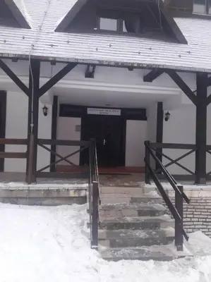 a building with a door and stairs in the snow at Apartman Ema,Bela Reka,Brzece in Brzeće