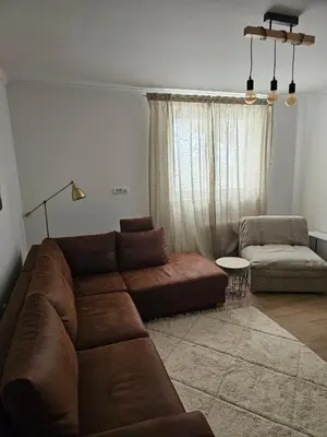 a living room with a brown couch and a chair at Studio Leone Sunčana Planina in Kopaonik