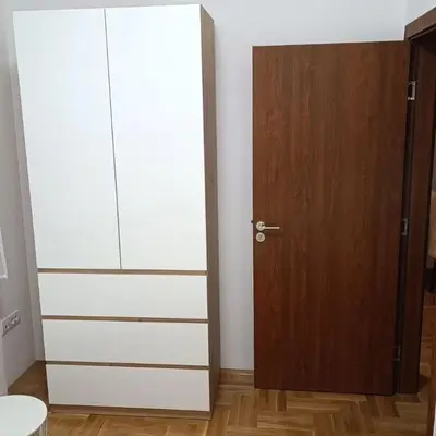 a room with a white cabinet and a wooden door at Apartman Zapadni Kej M&M in Pirot