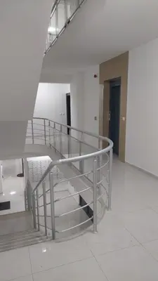 a metal spiral staircase in a large room at Apartman Zapadni Kej M&M in Pirot