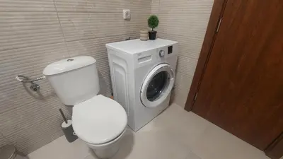 a bathroom with a toilet and a washing machine at Apartman Zapadni Kej M&M in Pirot