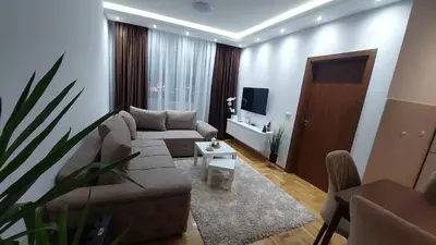 a living room with a couch and a tv at Apartman Zapadni Kej M&M in Pirot