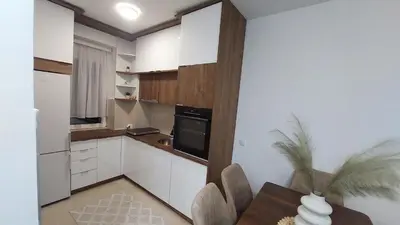a kitchen with white cabinets and a black appliance at Apartman Zapadni Kej M&M in Pirot