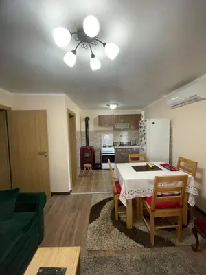 a living room with a table and a kitchen at Vila Meadow in Gredetin