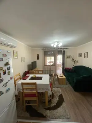 a living room with a table and a green couch at Vila Meadow in Gredetin