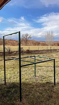 a batting cage in the middle of a field at Vila Meadow in Gredetin