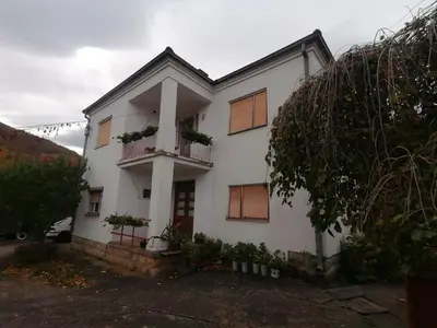 a white house with a porch and a balcony at Kuca za odmor Marina Jelenkovic in Knjazevac.