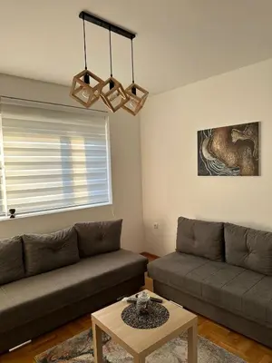 a living room with a couch and a table at Afrodita apartman in Vrnjci