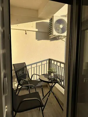 a balcony with a table and chairs and a fan at Afrodita apartman in Vrnjci