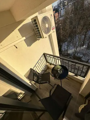 a balcony with a table and chairs and a fan at Afrodita apartman in Vrnjci