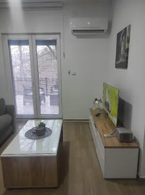 a living room with a table and a tv at Cera luxe apartment in Soko Banja