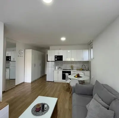 a living room and kitchen with a couch and a table at Cera luxe apartment in Soko Banja