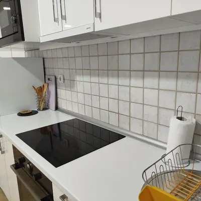a kitchen with white cabinets and a counter top at Cera luxe apartment in Soko Banja