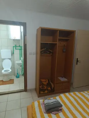 a bedroom with a bed and a bathroom with a toilet at Vila Jovana in Rogljevo