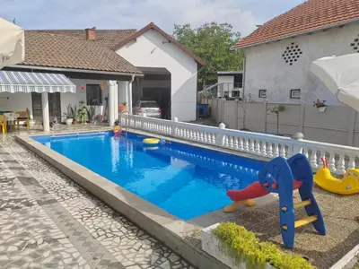 a swimming pool in front of a house at Vila Jovana in Rogljevo