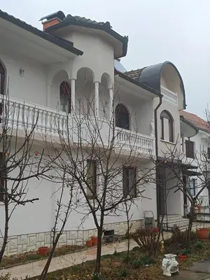 a white house with a tree in front of it at Vila Jovana in Rogljevo