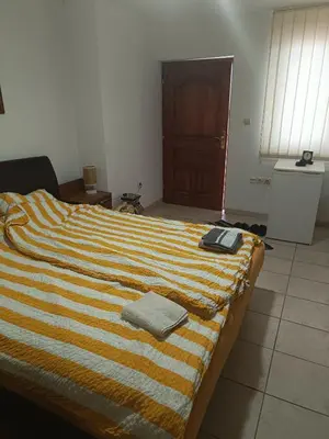 a bed with a striped blanket and a book on it at Vila Jovana in Rogljevo
