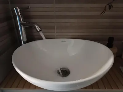 a white sink with a faucet in a bathroom at M Central Park in Niš