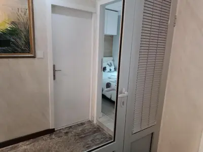 a door with a mirror next to a bedroom at M Central Park in Niš