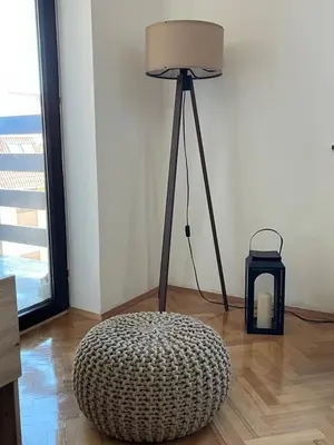 a lamp sitting in a room with a ottoman at Stanoteka in Vrnjačka Banja