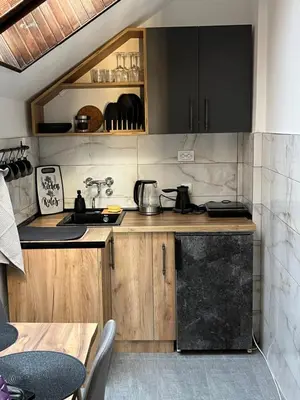 a kitchen with wooden cabinets and a black refrigerator at Stanoteka in Vrnjačka Banja
