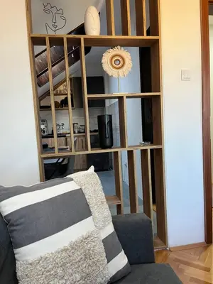 a living room with a couch and a book shelf at Stanoteka in Vrnjačka Banja