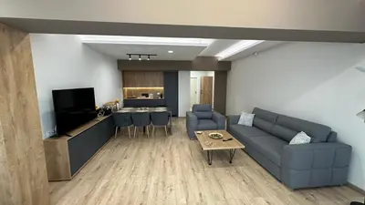 a living room with a couch and a table and a kitchen at South Apartmani in Vranje