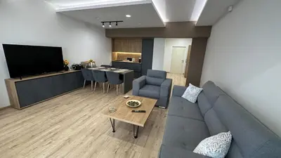 a living room with a couch and a table and a kitchen at South Apartmani in Vranje