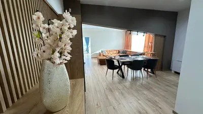 a living room with a vase with white flowers in it at South Apartmani in Vranje