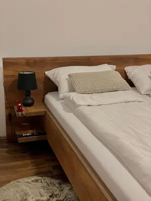 a bed with white sheets and a lamp on a table at Vila Bosa - Stara planina in Crni Vrh