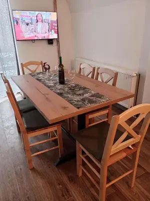 a wooden table with chairs and a bottle of wine at Vila Bosa - Stara planina in Crni Vrh