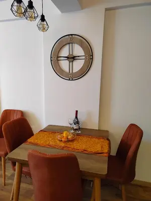 a dining room table with a large clock on the wall at President Kop Paxson in Kopaonik