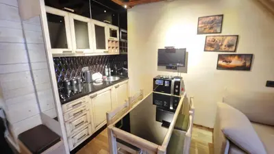 a small kitchen with a bar and a tv at Konaci”Rile-Men” in Kopaonik