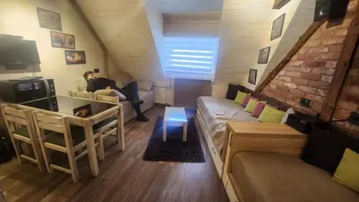 a woman sitting on a couch in a living room at Konaci”Rile-Men” in Kopaonik